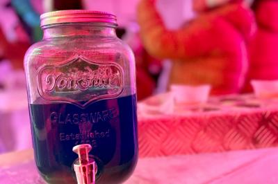 Table élégamment dressée avec nappe bleue, verres, couverts et un menu posé sur une serviette blanche.