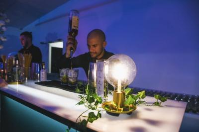 Table élégamment dressée avec nappe bleue, verres, couverts et un menu posé sur une serviette blanche.
