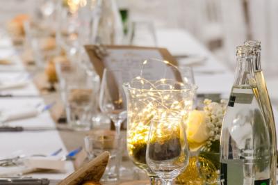 Table élégamment dressée avec nappe bleue, verres, couverts et un menu posé sur une serviette blanche.