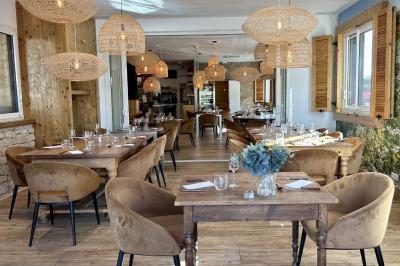 Table élégamment dressée avec nappe bleue, verres, couverts et un menu posé sur une serviette blanche.