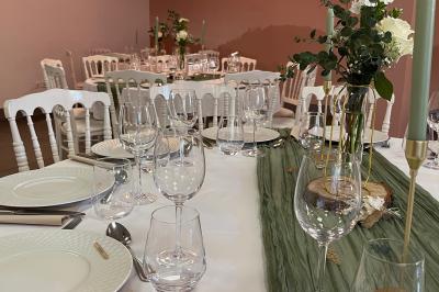 Table élégamment dressée avec nappe bleue, verres, couverts et un menu posé sur une serviette blanche.