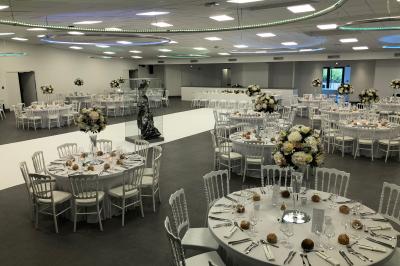 Table élégamment dressée avec nappe bleue, verres, couverts et un menu posé sur une serviette blanche.