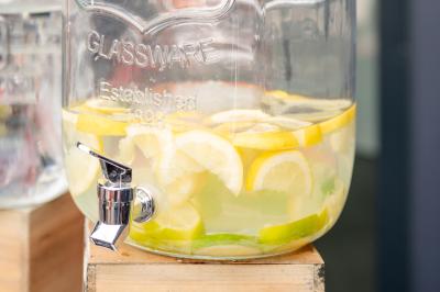 Table élégamment dressée avec nappe bleue, verres, couverts et un menu posé sur une serviette blanche.