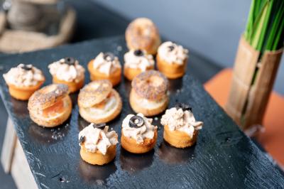 Table élégamment dressée avec nappe bleue, verres, couverts et un menu posé sur une serviette blanche.
