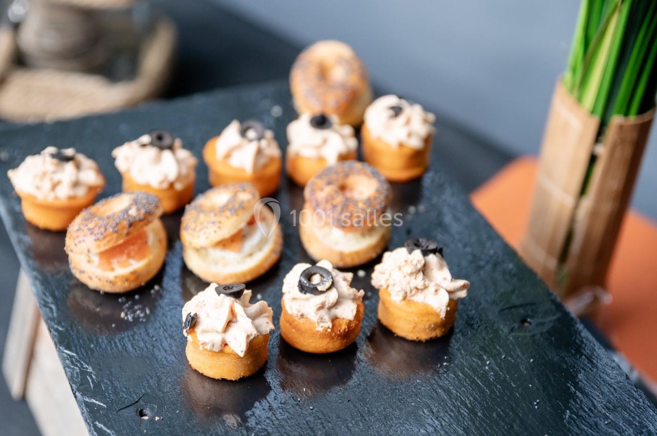 Assortiment de petits amuse-bouches salés disposés sur une ardoise noire.