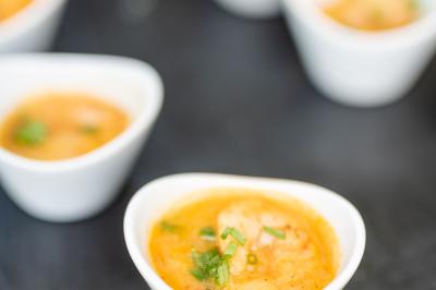 Table élégamment dressée avec nappe bleue, verres, couverts et un menu posé sur une serviette blanche.