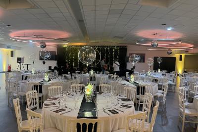 Table élégamment dressée avec nappe bleue, verres, couverts et un menu posé sur une serviette blanche.