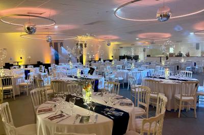Table élégamment dressée avec nappe bleue, verres, couverts et un menu posé sur une serviette blanche.