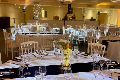 Table élégamment dressée avec nappe bleue, verres, couverts et un menu posé sur une serviette blanche.