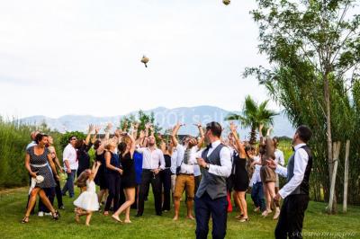 Un artiste chante sur scène avec une personne en costume étincelant sous des lumières violettes, devant un public assis.
