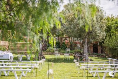 Un artiste chante sur scène avec une personne en costume étincelant sous des lumières violettes, devant un public assis.