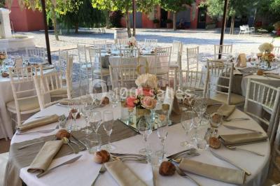 Un artiste chante sur scène avec une personne en costume étincelant sous des lumières violettes, devant un public assis.