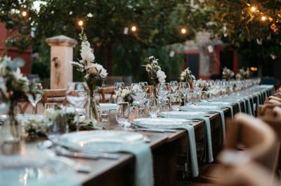 Un artiste chante sur scène avec une personne en costume étincelant sous des lumières violettes, devant un public assis.
