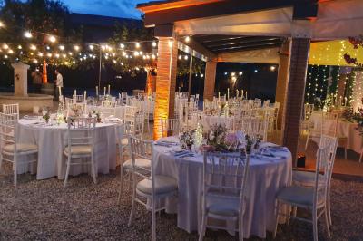 Un artiste chante sur scène avec une personne en costume étincelant sous des lumières violettes, devant un public assis.