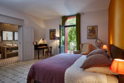 Un artiste chante sur scène avec une personne en costume étincelant sous des lumières violettes, devant un public assis.