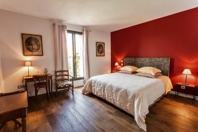 Un artiste chante sur scène avec une personne en costume étincelant sous des lumières violettes, devant un public assis.