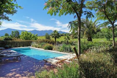 Un artiste chante sur scène avec une personne en costume étincelant sous des lumières violettes, devant un public assis.