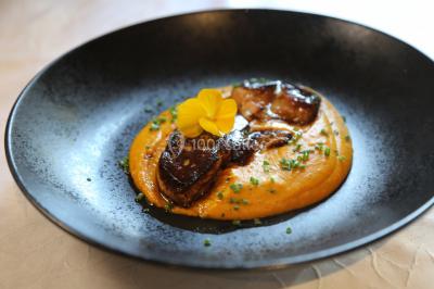 Gâteau rectangulaire décoré de fruits rouges, de crème et de bougies indiquant le chiffre 60, posé sur un plateau argenté.