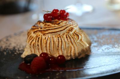Gâteau rectangulaire décoré de fruits rouges, de crème et de bougies indiquant le chiffre 60, posé sur un plateau argenté.