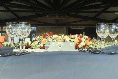 Gâteau rectangulaire décoré de fruits rouges, de crème et de bougies indiquant le chiffre 60, posé sur un plateau argenté.