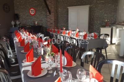 Jardin ensoleillé avec des palmiers au premier plan, pelouse verte et tables hautes recouvertes de nappes noires en arrière…