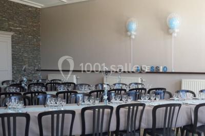 Jardin ensoleillé avec des palmiers au premier plan, pelouse verte et tables hautes recouvertes de nappes noires en arrière…