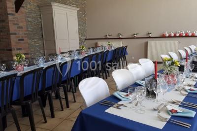 Jardin ensoleillé avec des palmiers au premier plan, pelouse verte et tables hautes recouvertes de nappes noires en arrière…