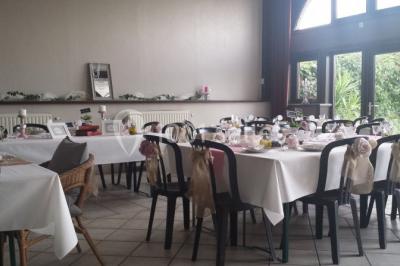 Jardin ensoleillé avec des palmiers au premier plan, pelouse verte et tables hautes recouvertes de nappes noires en arrière…