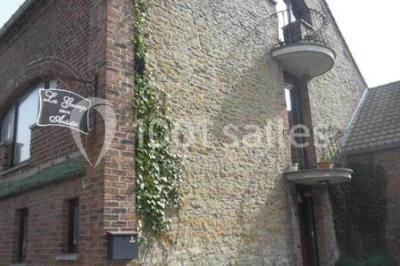 Jardin ensoleillé avec des palmiers au premier plan, pelouse verte et tables hautes recouvertes de nappes noires en arrière…