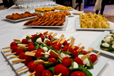 Plateaux de bouchées apéritives variées, incluant brochettes de tomates-mozzarella et autres amuse-bouches.