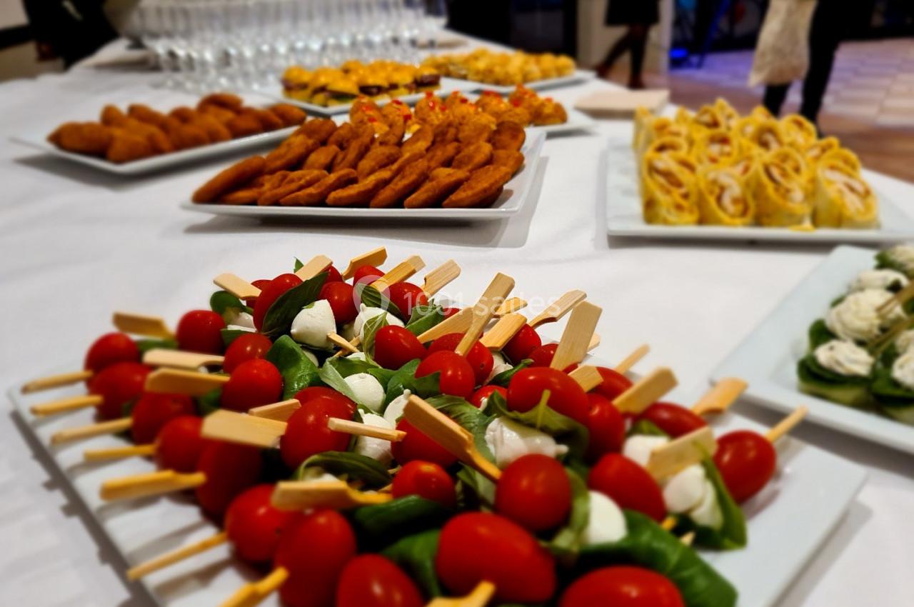 Plateaux de bouchées apéritives variées, incluant brochettes de tomates-mozzarella et autres amuse-bouches.
