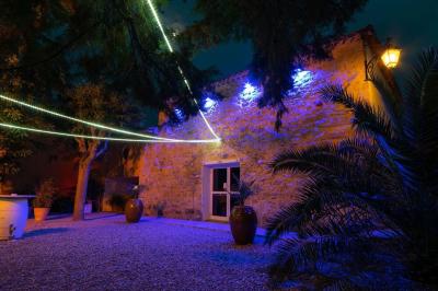 Terrasse en bois avec tables et chaises sous un parasol en chaume, entourée de végétation et de fleurs colorées.