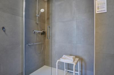 Salle de réunion avec tables rondes dressées de nappes blanches, chaises noires et fournitures de bureau.