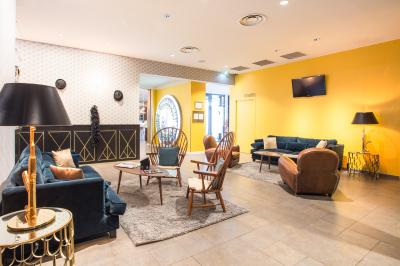 Salle de réunion avec tables rondes dressées de nappes blanches, chaises noires et fournitures de bureau.