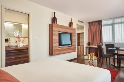 Salle de réunion avec tables rondes dressées de nappes blanches, chaises noires et fournitures de bureau.