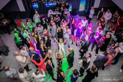 Un couple danse au milieu d'une piste entourée de fumée, avec des lettres géantes formant ’LOVE’ en arrière-plan.