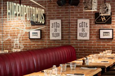 Plat de viande rouge tranchée avec sauce au poivre, accompagné de frites, servi sur un plateau avec un verre de vin rouge.