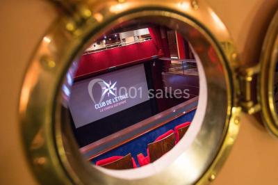 Façade du cinéma ’Club de l'Étoile’ avec une entrée vitrée et des voitures stationnées devant.