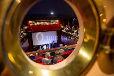 Façade du cinéma ’Club de l'Étoile’ avec une entrée vitrée et des voitures stationnées devant.