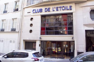 Façade du cinéma ’Club de l'Étoile’ avec une entrée vitrée et des voitures stationnées devant.