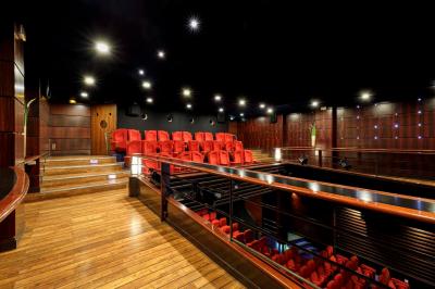 Façade du cinéma ’Club de l'Étoile’ avec une entrée vitrée et des voitures stationnées devant.