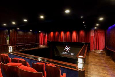 Façade du cinéma ’Club de l'Étoile’ avec une entrée vitrée et des voitures stationnées devant.