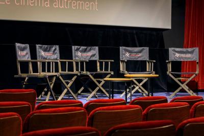 Façade du cinéma ’Club de l'Étoile’ avec une entrée vitrée et des voitures stationnées devant.