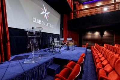 Façade du cinéma ’Club de l'Étoile’ avec une entrée vitrée et des voitures stationnées devant.