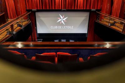 Façade du cinéma ’Club de l'Étoile’ avec une entrée vitrée et des voitures stationnées devant.