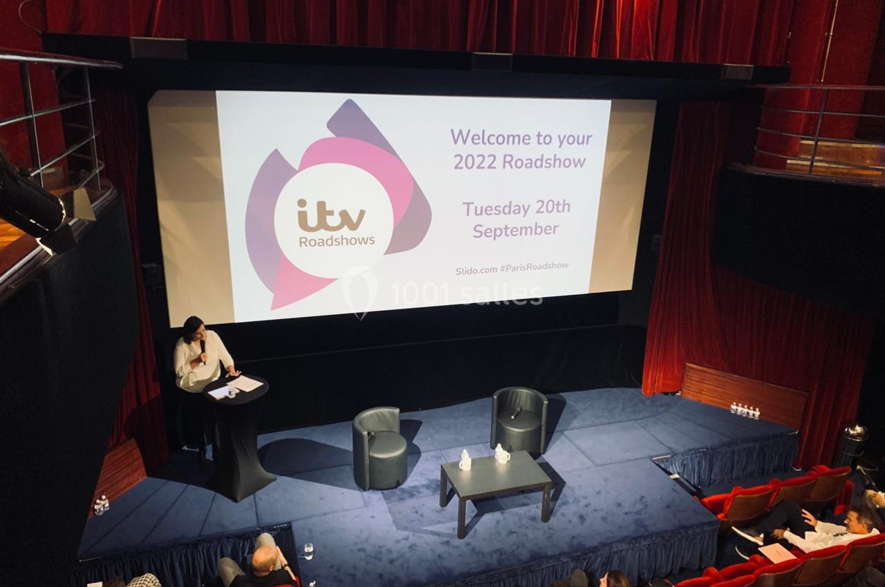 Vue d'une salle de conférence avec un écran affichant des informations sur un événement intitulé ’ITV Roadshows’.