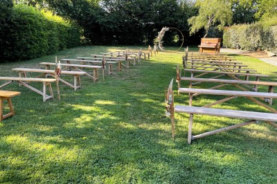 Chambre mansardée avec lit double, poutres apparentes, éclairage chaleureux et fenêtre de toit.