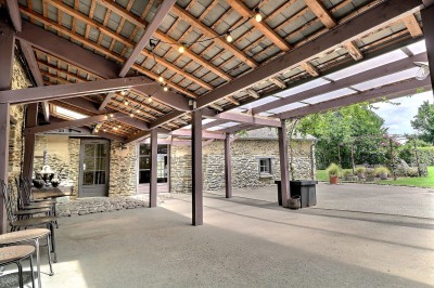 Chambre mansardée avec lit double, poutres apparentes, éclairage chaleureux et fenêtre de toit.