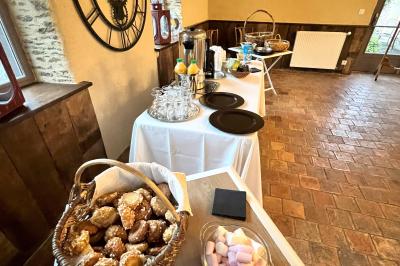 Miniature Café d'accueil buffet Chambre mansardée avec lit double, bureau en bois, malles anciennes et murs en pierre apparente.