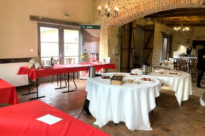 Miniature Café d'accueil dans la salle Chambre mansardée avec lit double, bureau en bois, malles anciennes et murs en pierre apparente.